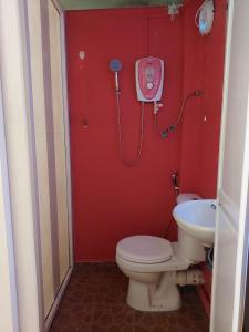 a red bathroom with a toilet and a sink at Warisan Family inn @ Seafront in Semporna