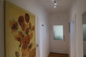 un pasillo con una pintura de flores en la pared en Happy 1 en Quierschied