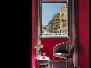 a red room with a chair and a window at C'est La Vie Suites in Rome