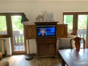 a living room with a television with a child on it at Haus Fremerey in Krün