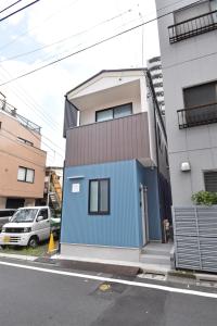 a building with a blue door on the side of a street at ID STAY Ikebukuro 済 in Tokyo