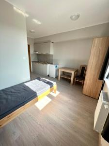 a bedroom with a bed and a table in it at OSPER Rooms in Łomża