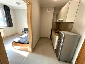 a small kitchen with a refrigerator and a table at OSPER Rooms in Łomża