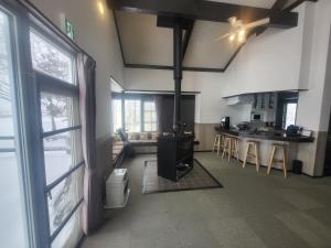 a kitchen with a stove in the middle of a room at Hakuba Powder Lodge in Hakuba