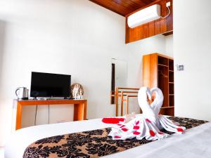 a room with a bed with a swan on it at Pratasaba Resort in Maratua Atoll