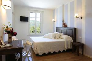 1 dormitorio con cama, escritorio y ventana en Villa Gelsomina, en Parma