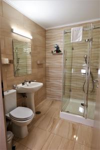 a bathroom with a toilet and a sink and a shower at Park Luxury Rooms in Predeal