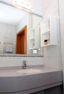 ein Bad mit einem Waschbecken und einem Spiegel in der Unterkunft Wohlfühl Hotel Wiesenhof in Grafendorf bei Hartberg
