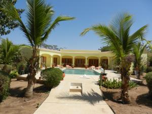 ein Resort mit einem Pool und Palmen in der Unterkunft Villa au Tamtam in Gandigal