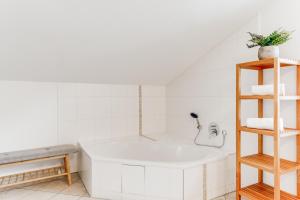 uma casa de banho branca com uma banheira e um lavatório em VYLD: Bad Hindelang inmitten der Berge em Bad Hindelang