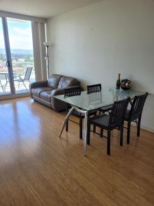 a living room with a glass table and a couch at GlenelgApt in Adelaide