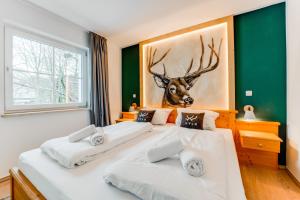 Duas camas num quarto com uma cabeça de veado na parede em VYLD: Bad Hindelang inmitten der Berge em Bad Hindelang