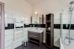 a bathroom with a sink and a mirror at The Originals City, Hôtel de l'Europe, Saint-Nazaire in Saint-Nazaire