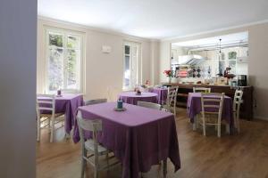 una sala da pranzo con tavoli e sedie viola di Villa Gelsomina a Parma