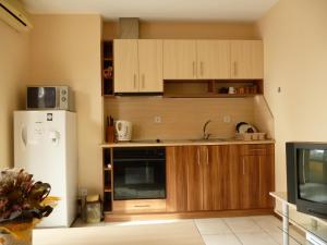 a kitchen with wooden cabinets and a white refrigerator at Apt. Plovdiv in Plovdiv