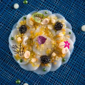 a dessert with fruit on top of a blue table at Hotel restaurant au gourmet in Drusenheim