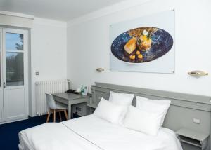 une chambre d'hôtel avec un lit et une assiette de nourriture sur le mur dans l'établissement Hotel restaurant au gourmet, à Drusenheim