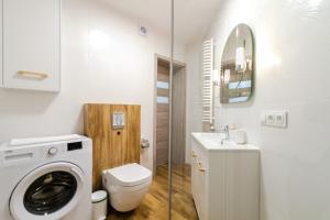 Un baño con lavadora y un inodoro. en Apartament Flower z tarasem - Dream Apart, en Ustroń 12 fotos más