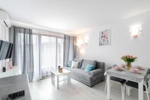 una sala de estar con un sofá y una mesa en Apartament Flower z tarasem - Dream Apart, en Ustroń