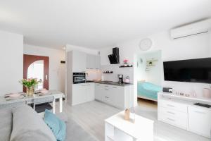 sala de estar blanca con sofá y cocina en Apartament Flower z tarasem - Dream Apart, en Ustroń