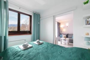 Un dormitorio con una cama verde y una ventana. en Apartament Flower z tarasem - Dream Apart, en Ustroń