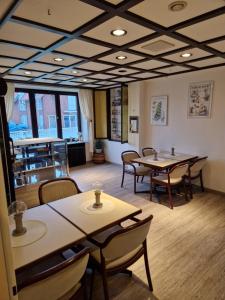 ein Restaurant mit Tischen und Stühlen in einem Raum in der Unterkunft Hotel Meeresfriede in Cuxhaven + 2 Fotos