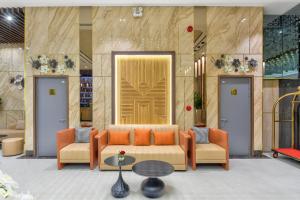 a lobby with a couch and two chairs and a table at Maris Hotel Nha Trang in Nha Trang