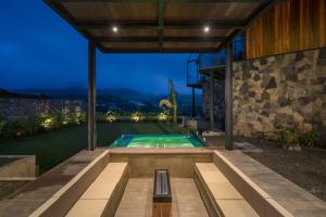 a house with a swimming pool at night at Sulanga Luxury Chalets in Nuwara Eliya