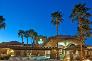 un hôtel avec des palmiers la nuit dans l'établissement Holiday Inn Express & Suites Rancho Mirage - Palm Spgs Area, an IHG Hotel, à Rancho Mirage