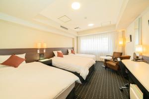 Habitación de hotel con 2 camas y lavamanos en Kanda Station Hotel, en Tokio