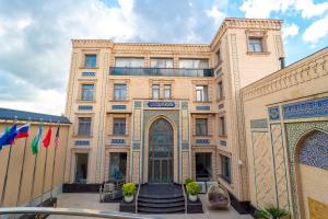 a large building with a gate in front of it at Shohjahon Palace Hotel & Spa in Samarkand