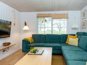 a living room with a green couch and a table at Modern Holiday Home in Rømø with Sauna in Toftum