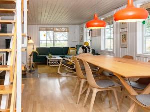 a living room with a table and a green couch at Modern Holiday Home in Rømø with Sauna in Toftum
