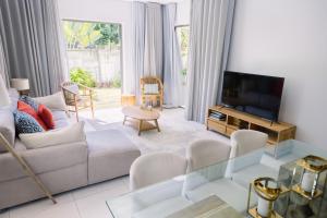 a living room with a white couch and a tv at The Spot with LOV in Grand Baie