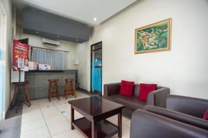 uma sala de estar com um sofá e uma mesa em RedDoorz Plus near Universitas Indonesia em Jakarta