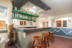 a bar in a restaurant with stools at RedDoorz Plus near Universitas Indonesia in Jakarta