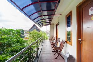 balkon budynku z krzesłami i poręczą w obiekcie RedDoorz Plus near Universitas Indonesia w Dżakarcie