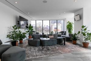 uma sala de estar com sofás e vasos de plantas em Clinton Hill 2br w wd gym pool nr BAM NYC-971 em Brooklyn