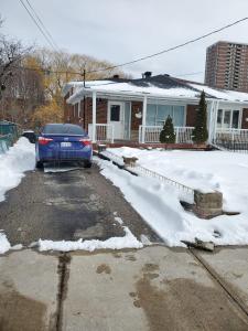 een blauwe auto geparkeerd op een oprit voor een huis bij Maxwell Esabu in Toronto