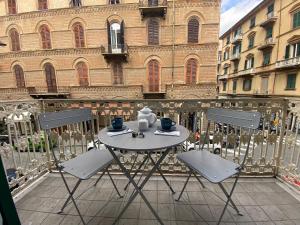 een tafel en stoelen op een balkon voor een gebouw bij Rosselli 74 by Arbaspàa in La Spezia