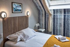 une chambre d'hôtel avec un lit et une table dans l'établissement Hotel La Voilerie Cancale bord de mer, à Cancale