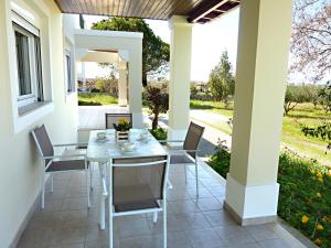 een patio met een witte tafel en stoelen erop bij Panoramic Sea View Villa 4 Min to Beach in Tigaki