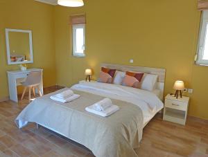 a bedroom with a large bed with two towels on it at Panoramic Sea View Villa 4 Min to Beach in Tigaki