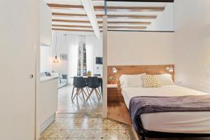 a bedroom with a bed and two chairs in it at Flateli Borrell in Barcelona