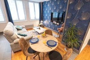 uma sala de estar com uma mesa e um sofá em Joli T2 tout équipé Quartier Piéton par Groom* em Lorient