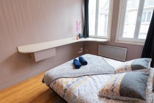 una camera da letto con un letto con due cuscini blu sopra di Joli T2 tout équipé Quartier Piéton par Groom* a Lorient