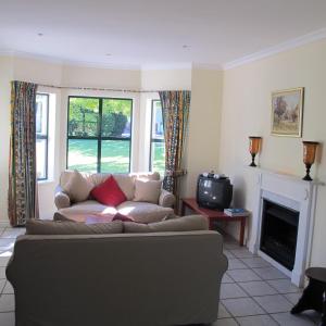 a living room with a couch and a tv at Constantia Cottage in Cape Town
