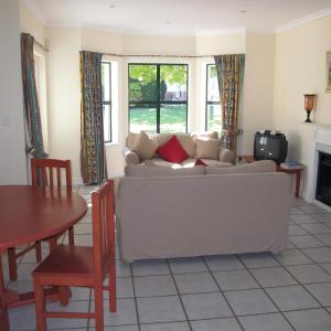 a living room with a white couch and a table at Constantia Cottage in Cape Town