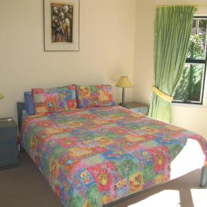 a bedroom with a large bed and a window at Constantia Cottage in Cape Town +10 photos