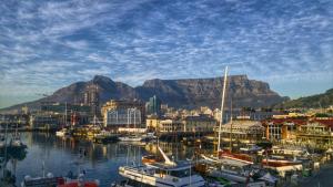 a group of boats docked in a harbor with a mountain at Constantia Cottage in Cape Town